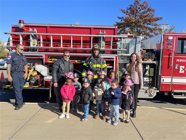 Students pose with firefighters and fire truck